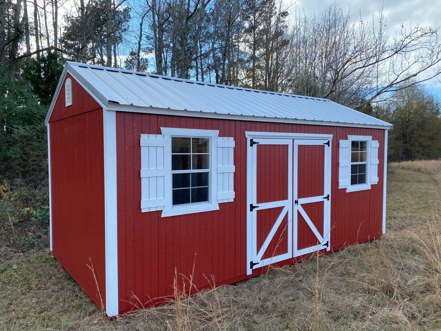 Barn-red utility shed with white shutters and an A-frame roof